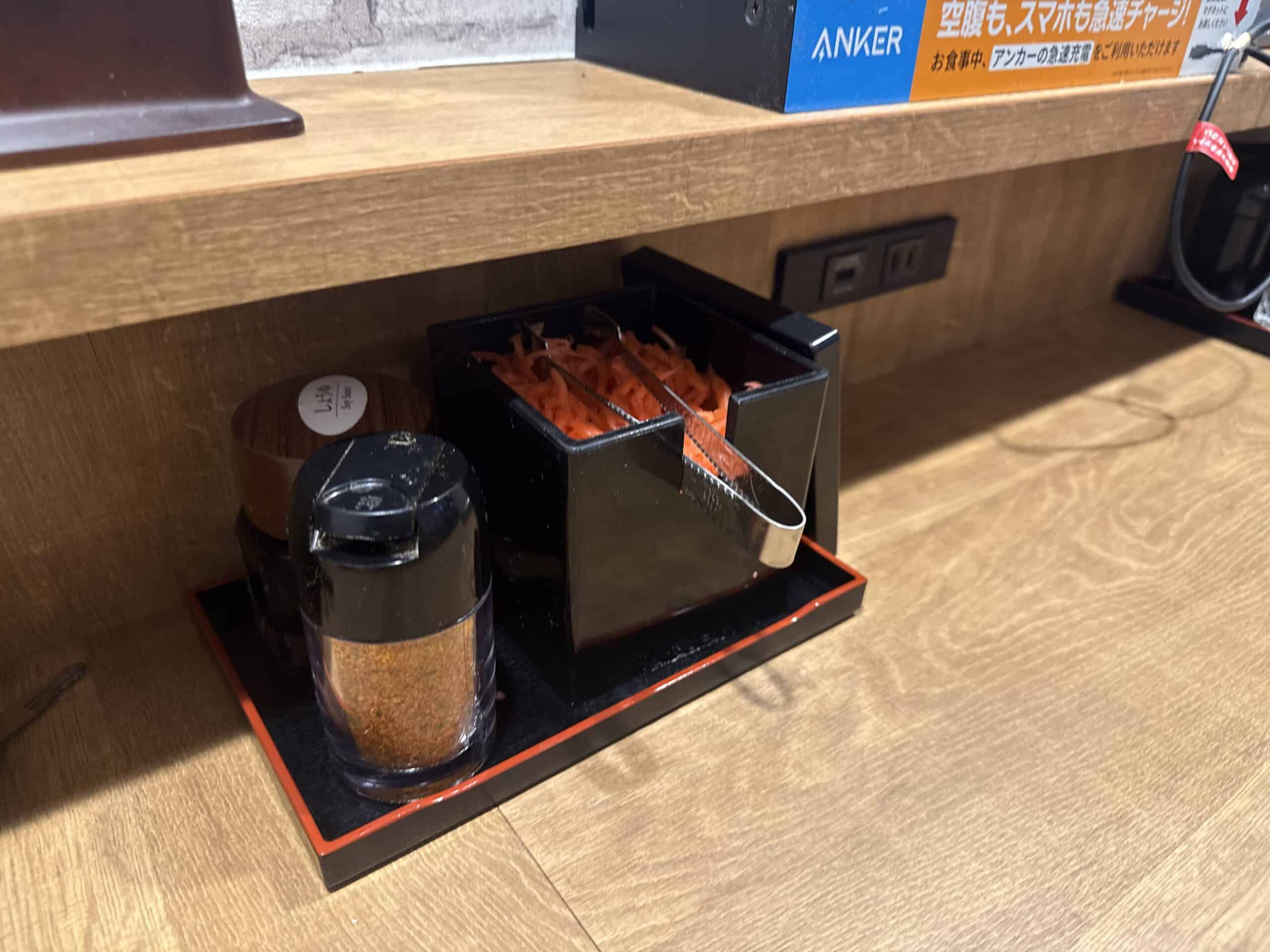 Free red pickled ginger and shichimi chili pepper at Yoshinoya table